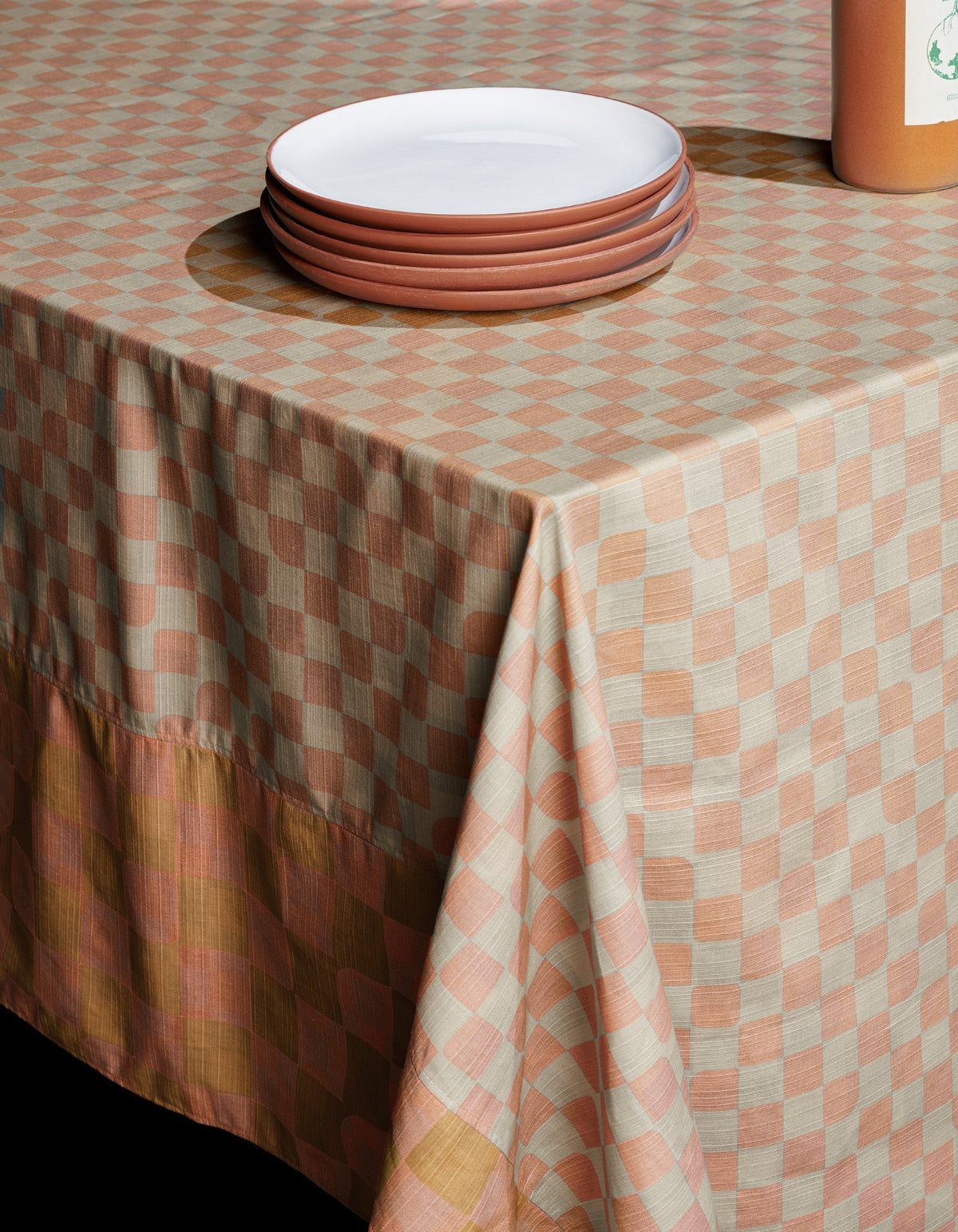 Checker tablecloth in peach and browns sets a warm, soft table.